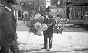 Balloon Vendor in the Streets at Unidentified Circus or Carnival