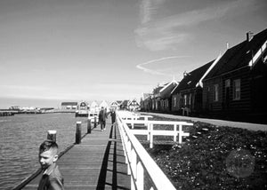 Pedestrians Walking on the Docks of a Lovely Cabin-Lined Harbor in Holland