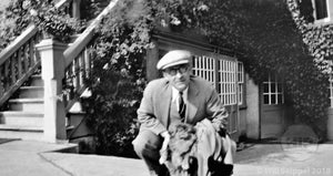 1920s Man in Suit Sitting Outside House Entrance Draped in Ivy