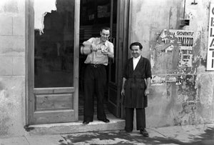 Two men on the streets of Italy, pouring out a well-deserved toast.