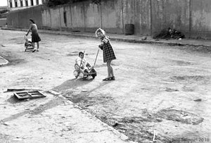 Little Girl Around 6 Years Old Playing in Street with Baby Sibling in WWII Italy