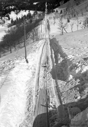 Cable Tracks Running Through A Gentle-Sloping Mountain Range Adorned with Pine Trees in Winter