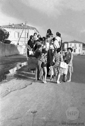 Crowd of Primarily Young Women and Children Boarding the Back of a Truck in Summertime, Italy
