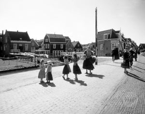 Young Girls in Traditional Dress-Wear Conversing Together on the Streets of a Quaint Dutch Village in Holland